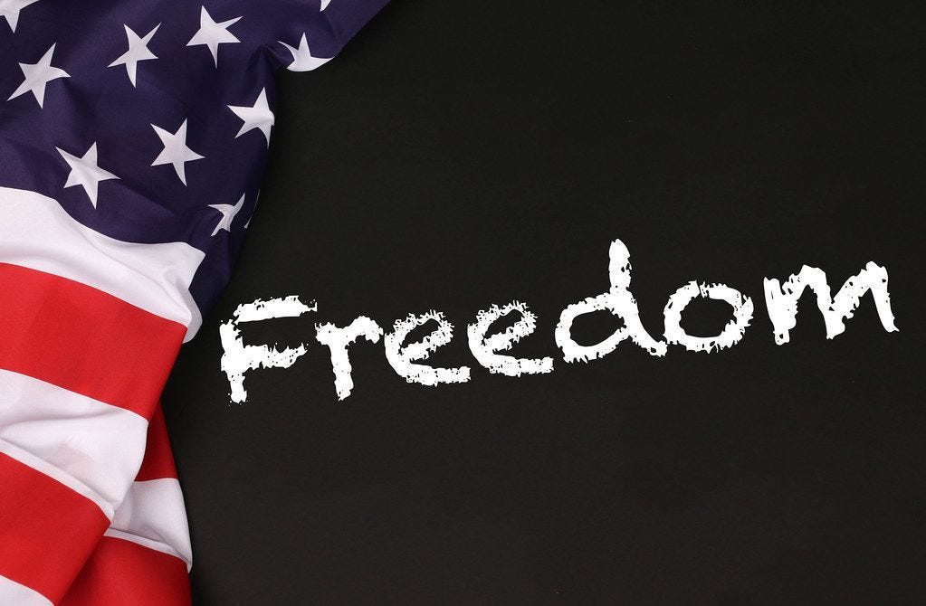 https://foto.wuestenigel.com/wp-content/uploads/api/american-flag-with-the-text-freedom-against-a-blackboard-background.jpeg