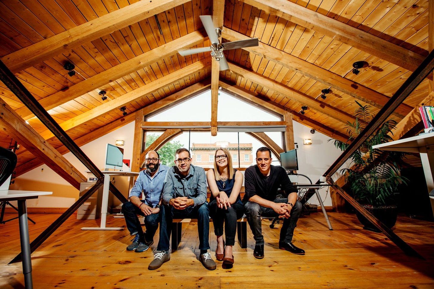 four people sitting and looking at the camera in a wood studio four people sitting and looking at the camera in a wood studio