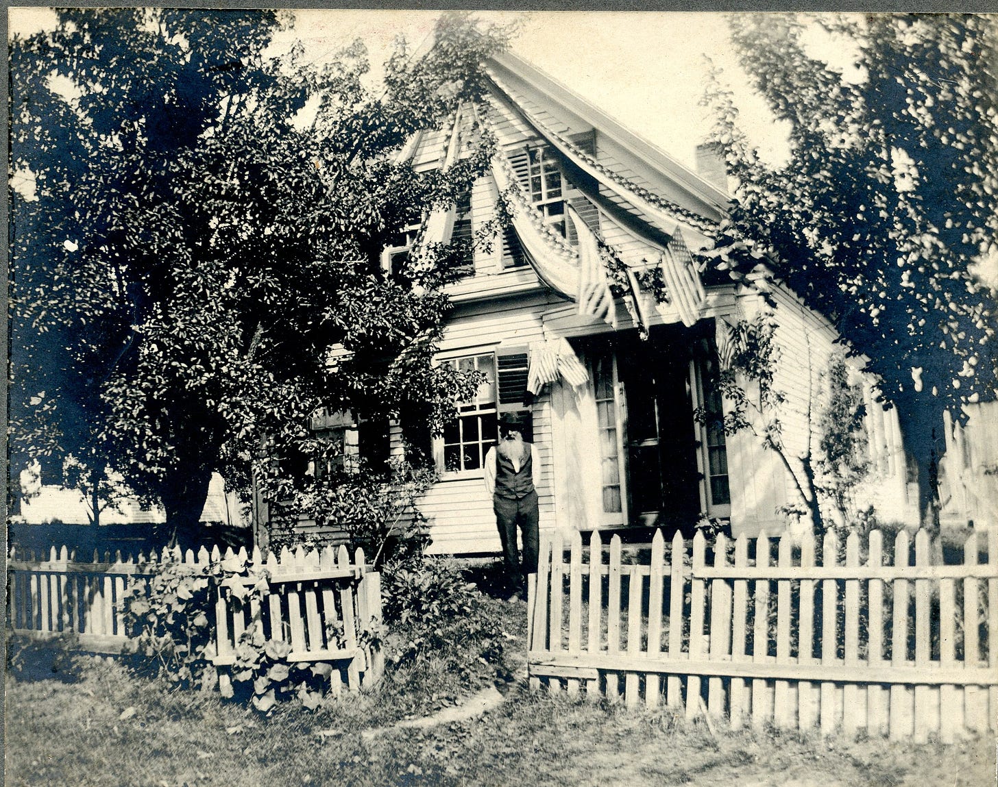 Man standing in front of house with bunting