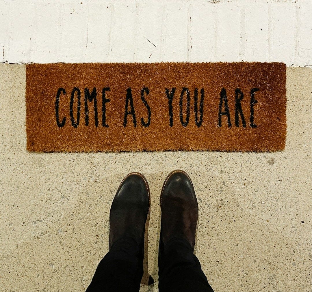 person standing on brown and black welcome printed floor mat