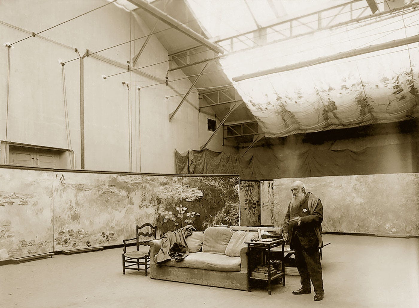 Monet in his Giverny studio built in 1915 for the Water Lilies cycle, photo by Henri Manuel circa 1920.