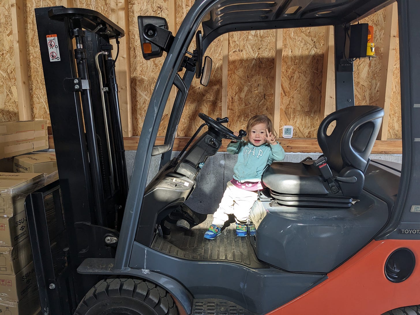 Young child playing on forklift machinery inside Kamui Whisky K.K. warehouse