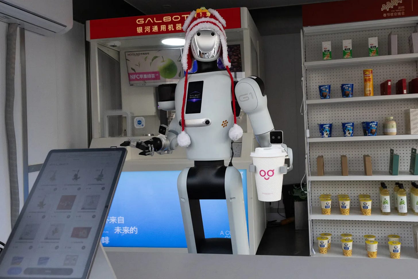A Galbot robot hands a journalist a coffee at a Galaxy capsule retail store during an organized media tour, in Beijing, China, 23 March 2026. A Galbot robot hands a journalist a coffee at a Galaxy capsule retail store during an organized media tour, in Beijing, China, 23 March 2026.