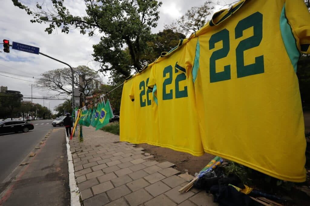 Yellow jerseys numbered 22 and Brazilian flags hung along a city sidewalk near Esquina da Liberdade street sign Yellow jerseys numbered 22 and Brazilian flags hung along a city sidewalk near Esquina da Liberdade street sign