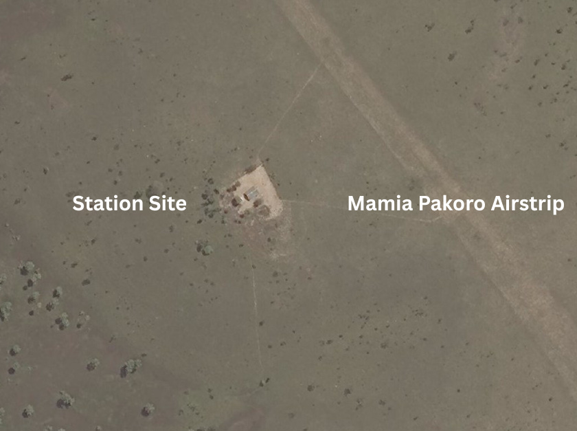 An annotated satellite photo of a remote savanna in Suriname. A text label points to a faint dirt airstrip labeled 'Mamia Pakoro Airstrip.' Another label points to a small, cleared area with a structure, labeled 'Station Site.