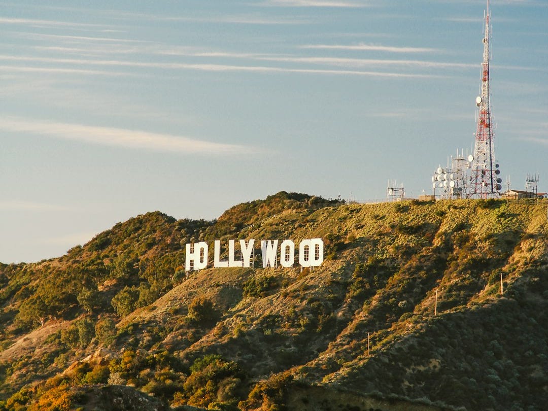 white and red tower on top of green mountain