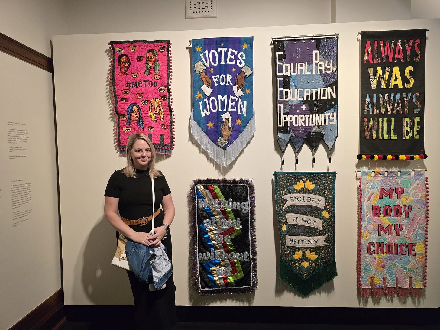 Annie stands in front of craft banners hanging in Parliament House Annie stands in front of craft banners hanging in Parliament House