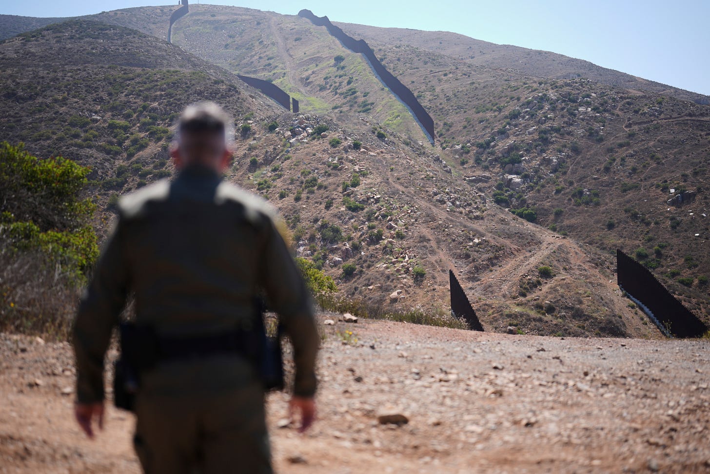 Border Patrol Agent Rood looks out to a gap in the two border walls separating Mexico and the United States on June 10. (AP Photo/Gregory Bull).