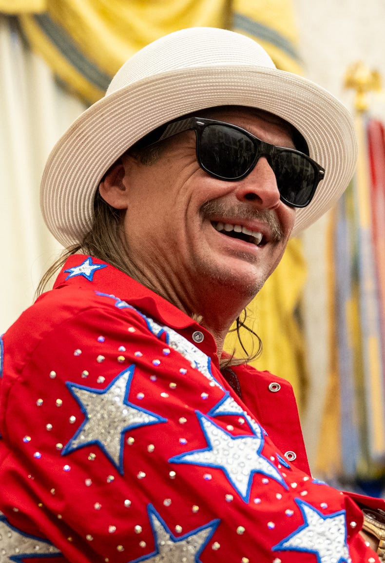 Kid Rock in broad brimmed hat, sunglasses, red shirt with stars; smiling at the White House Kid Rock in broad brimmed hat, sunglasses, red shirt with stars; smiling at the White House