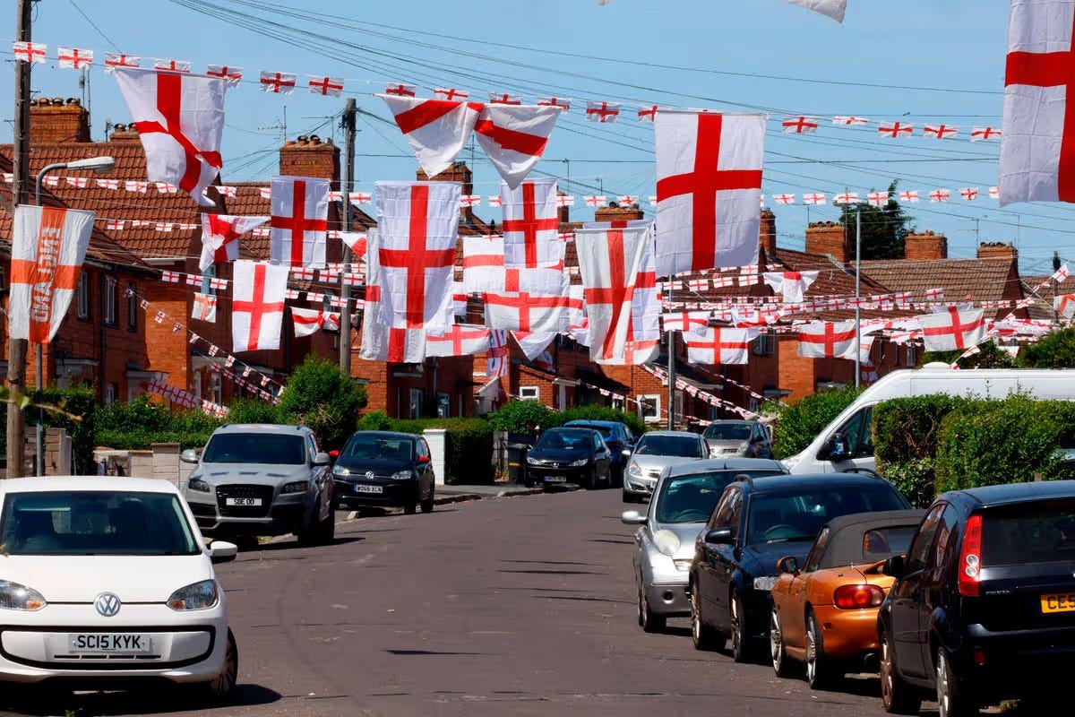 Bristol Torrington Avenue working-class neighbourhood displaying English St George's Cross flags across terraced houses - demonstrates class patterns in Bristol flag controversy - contrasts Palestine activism affluent areas versus working-class national identity displays housing crisis knife crime areas https://bit.ly/4tiNNbM