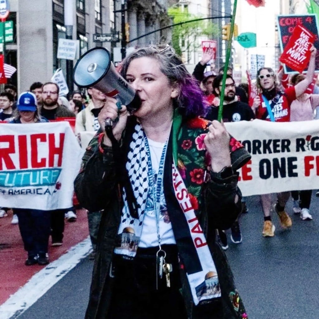 DSA labor coordinator Olivia Killingsworth with purple-dyed hair uses a megaphone to lead a protest. DSA labor coordinator Olivia Killingsworth with purple-dyed hair uses a megaphone to lead a protest.
