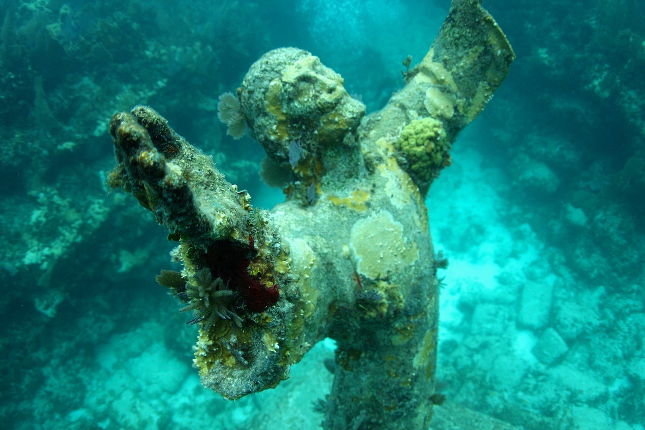 Statue of Christ underwater with barnacles in a green cast sea- Christ of the Abyss Statue of Christ underwater with barnacles in a green cast sea- Christ of the Abyss