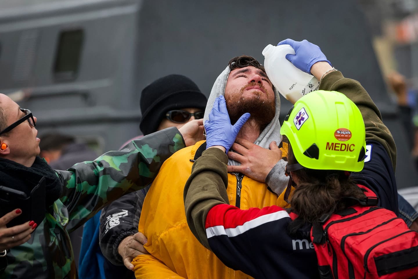 A medic pours milk into the eyes of a protestor for pepper spray. Photo / Mark Mitchell