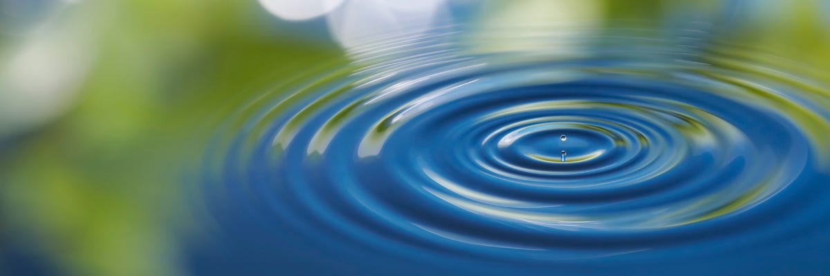 Ripples spread in a blue green pool of water