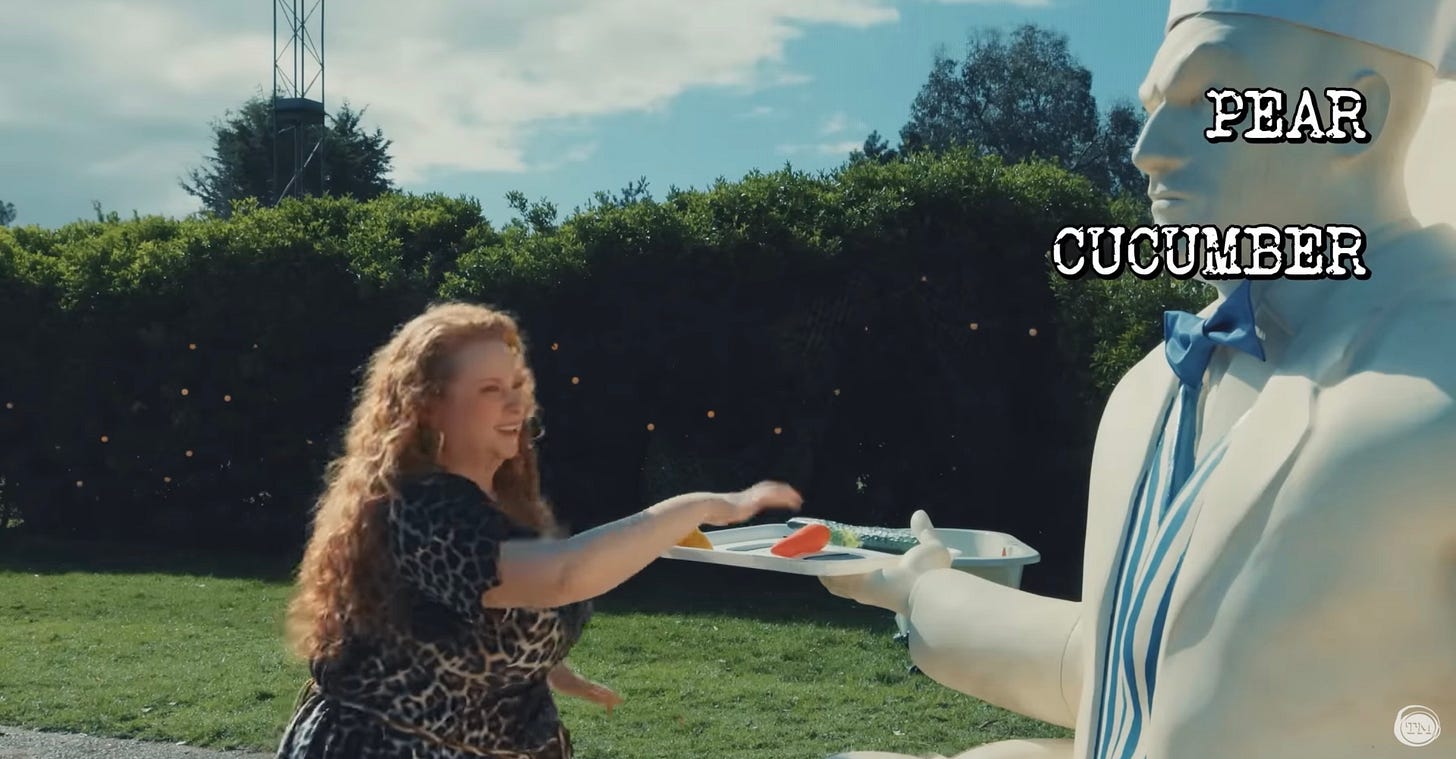 Amy Gledhill offers plastic fruit to a statue of Greg Davies