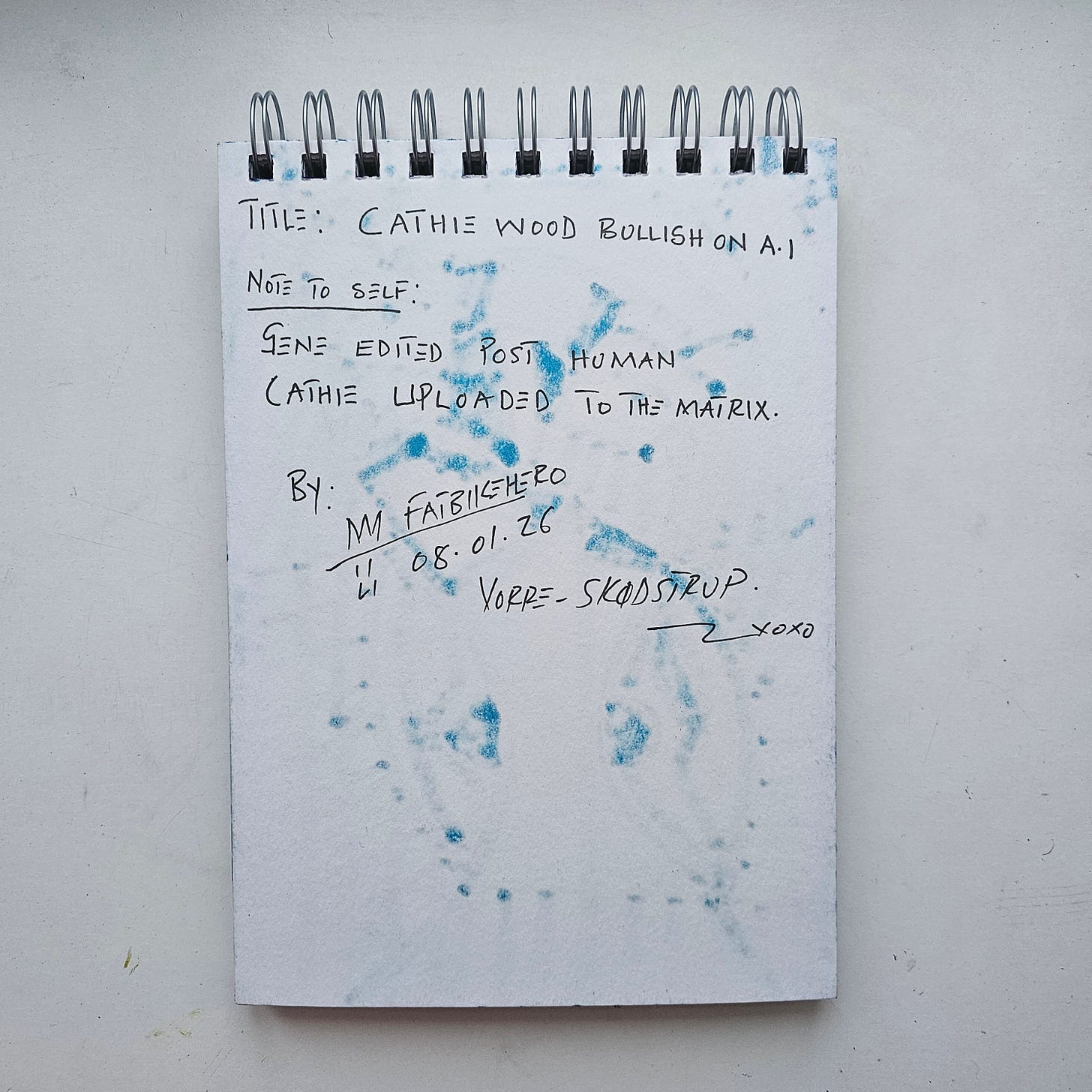 "The back of a sketchbook page with handwritten text in black ink. The text reads: 'Title: CATHIE WOOD BULLISH ON A.I. Note to Self: Gene edited post human Cathie uploaded to the Matrix.' The page is signed 'M FatbikeHero', dated '08.01.26', and inscribed 'Vorre - Skødstrup'. Blue marker ink from the front image has bled through, creating a scattered, spotted texture across the page." "The back of a sketchbook page with handwritten text in black ink. The text reads: 'Title: CATHIE WOOD BULLISH ON A.I. Note to Self: Gene edited post human Cathie uploaded to the Matrix.' The page is signed 'M FatbikeHero', dated '08.01.26', and inscribed 'Vorre - Skødstrup'. Blue marker ink from the front image has bled through, creating a scattered, spotted texture across the page."