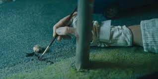 Miss Toni Collette Hereditary Mom painting blood onto a diorama.