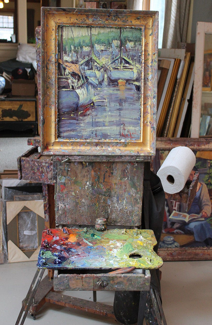 A painting on a stand next to a roll of paper

Description automatically generated
