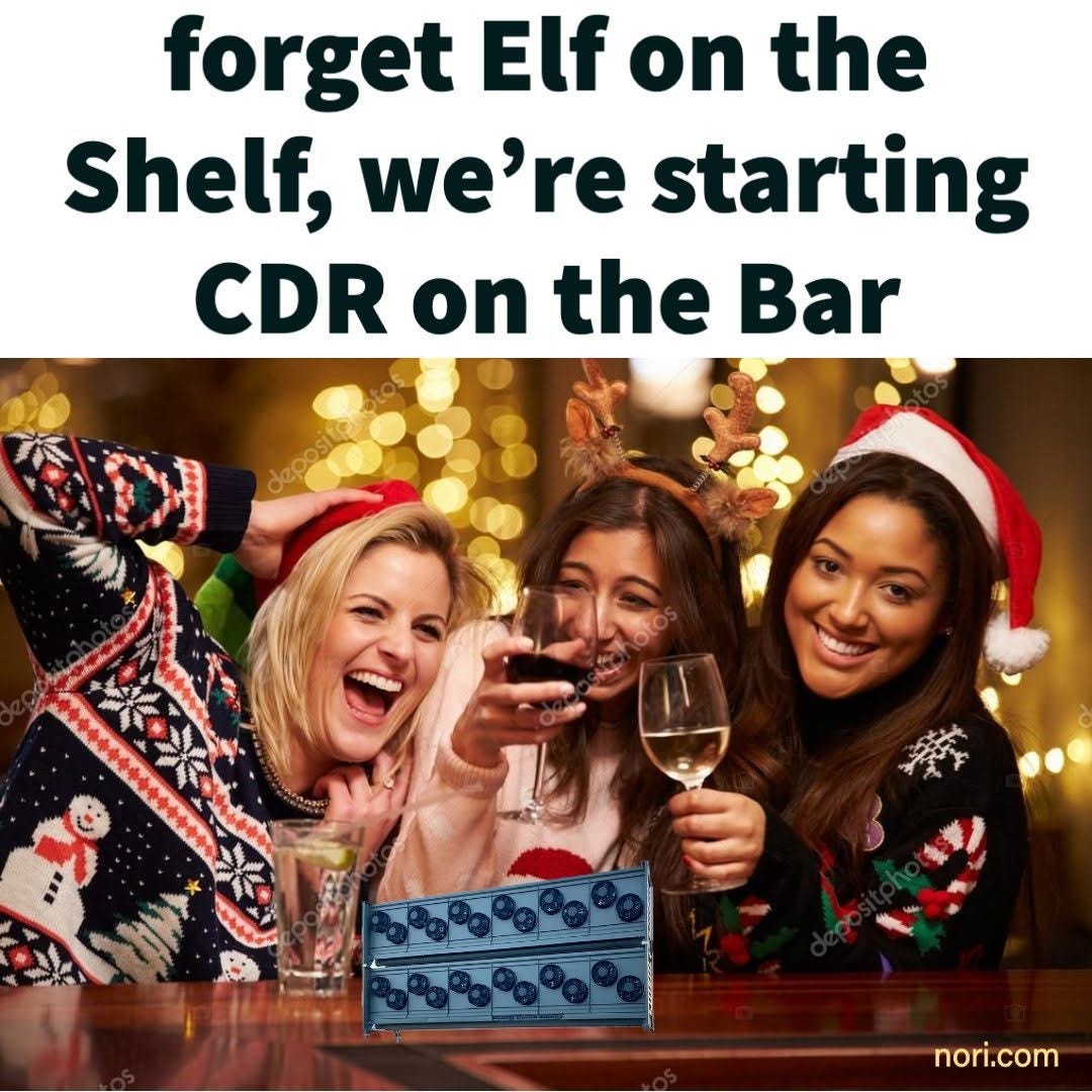 Text: "forget Elf on the Shelf, we're starting CDR on the Bar." Below, three women in Christmas jumpers laughing at a bar, with a small direct air capture unit pasted onto the bar top.