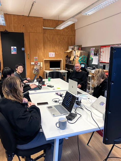 Images of an informal classroom setting where artsist look at creating zines nd computer graphics on screen 