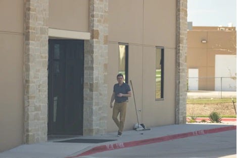 A person walking outside a building

Description automatically generated