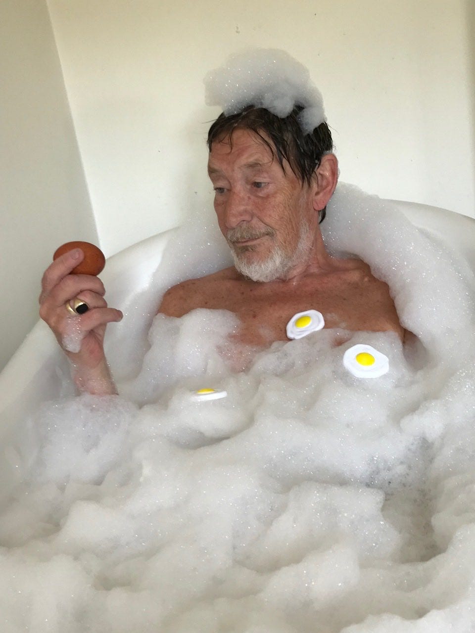 A photo of Chris Rea in the bath, pretending to poach eggs