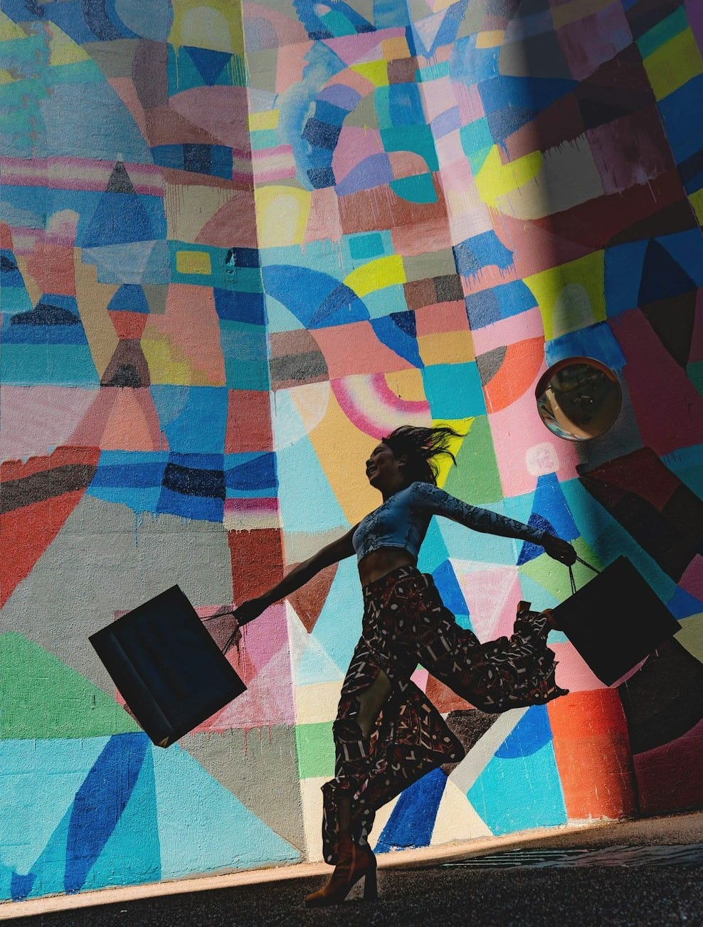 woman holding bag beside mural painting