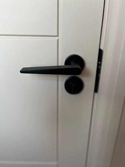 black tap, black shower, black door handle