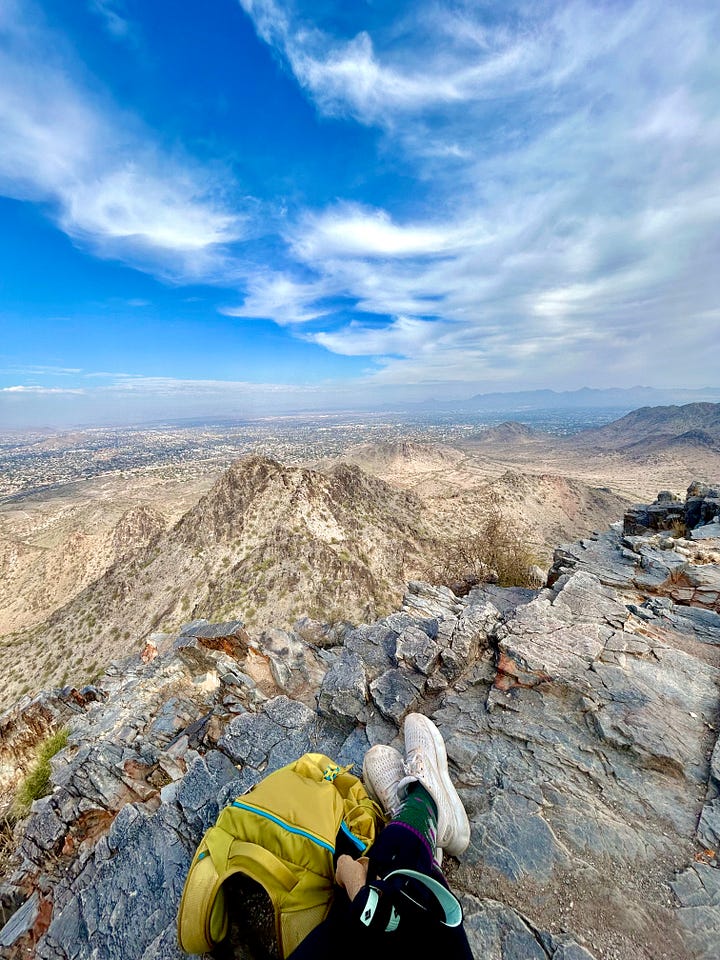 A photo of Adrianna's feet in athletic shoes at the top of a mountain; a photo of the mountain from the ground.