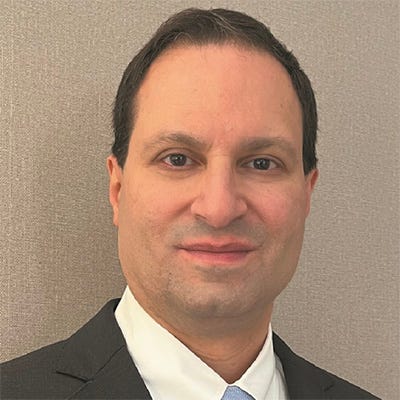 Um retrato em close de um homem adulto, usando terno escuro, camisa branca e gravata clara. Ele está de frente para a câmera, com expressão neutra e leve sorriso. O fundo é liso, em tom bege/cinza. Um retrato em close de um homem adulto, usando terno escuro, camisa branca e gravata clara. Ele está de frente para a câmera, com expressão neutra e leve sorriso. O fundo é liso, em tom bege/cinza.