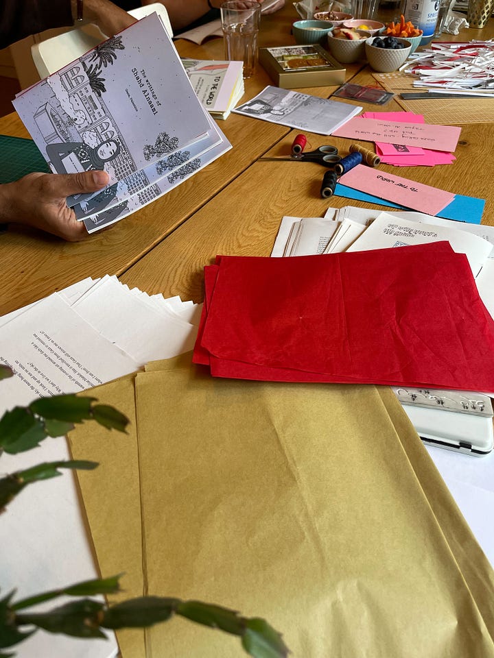 Four stacks of zines with illustrated covers on work table.