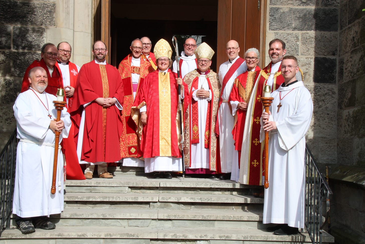 Many clergy dressed in white and accented with red, with the author among them.