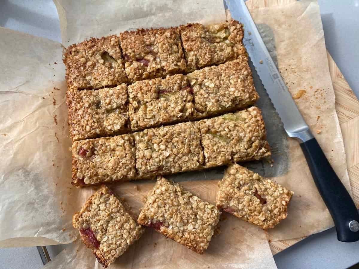 Golden brown rhubarb and ginger flapjacks in a baking tin, sliced into bars. Golden brown rhubarb and ginger flapjacks in a baking tin, sliced into bars.