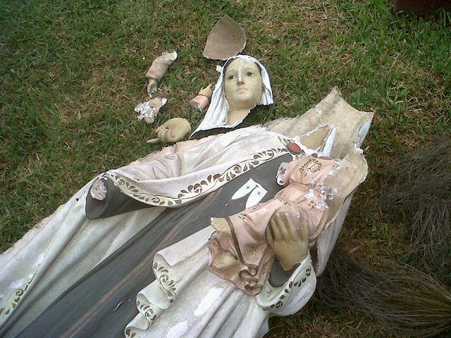 This may contain: the statue is laying on the grass with it's head covered in cloths