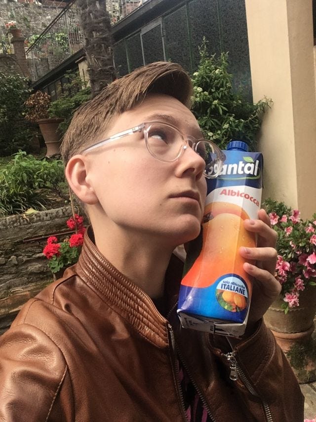 It is me, I am a white person with short brown hair, wearing glasses. I am pressing my face in a sort of romantic way to a box of apricot juice.