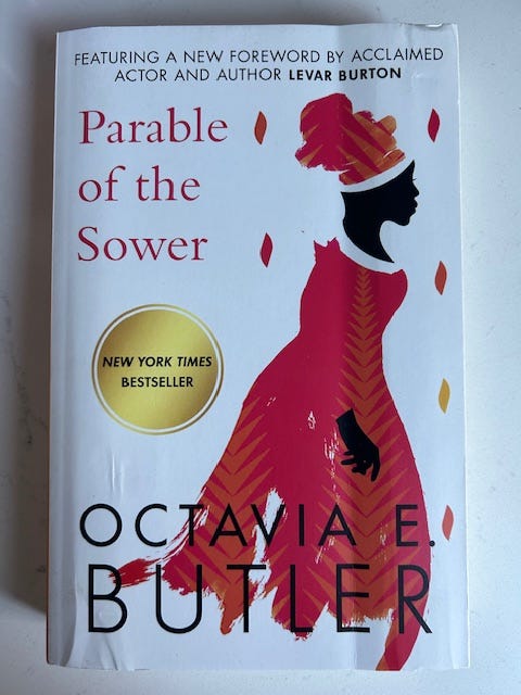Parable of the Sower by Octavia E. Butler has a woman wearing an orange dress. Parable of the Sower by Octavia E. Butler has a woman wearing an orange dress.