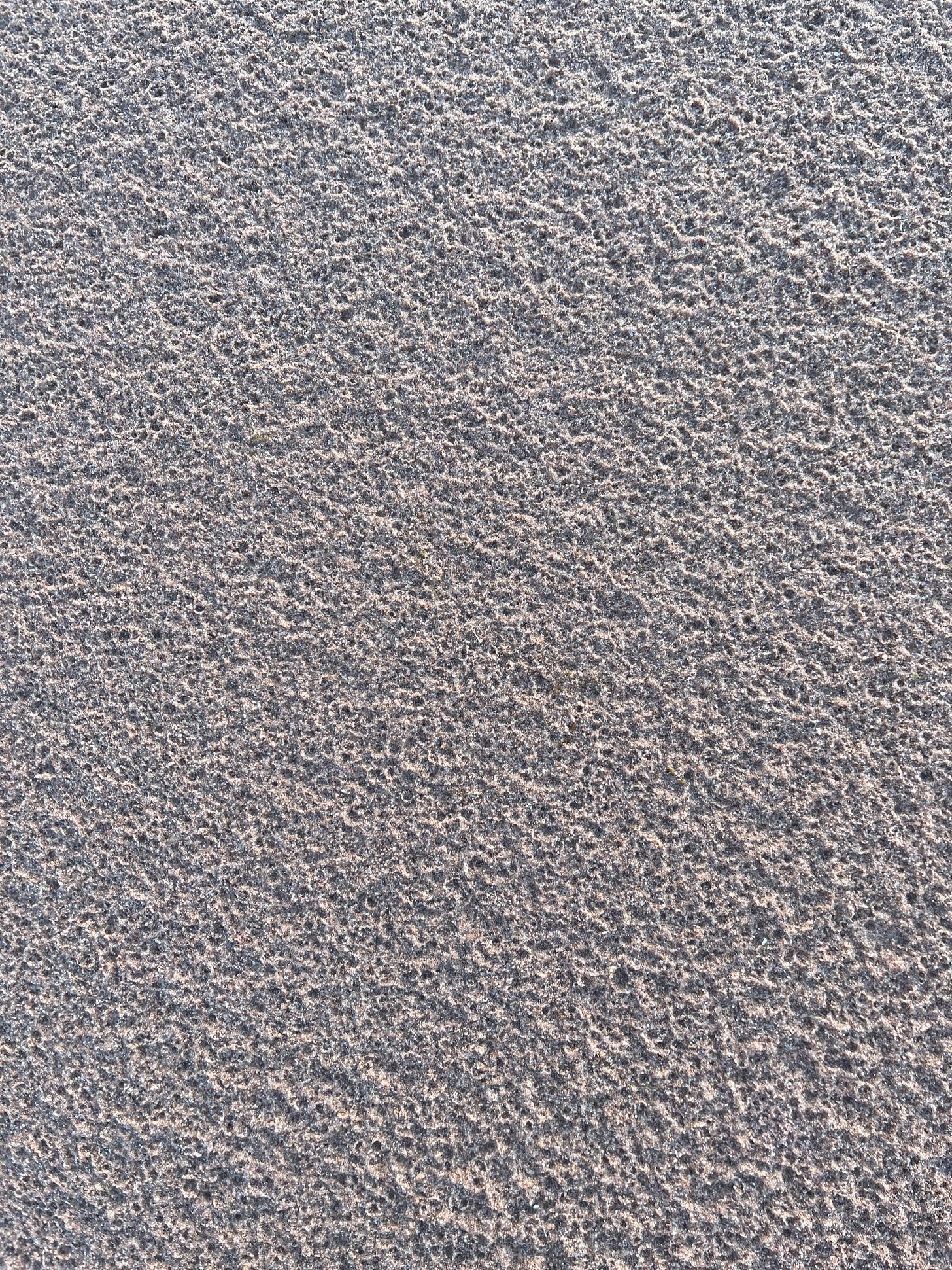 an image of the surface of the sandy beach, pock-marked by thousands of craters cause by rain drops an image of the surface of the sandy beach, pock-marked by thousands of craters cause by rain drops