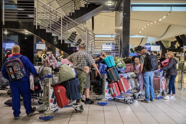 White South Africans in line with their baggage at an airport.