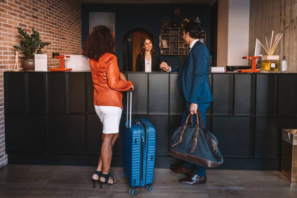 Business people checking-in at hotel reception desk Receptionist in a luxury hotel welcoming new guests at the hotel lobby. front desk of hotel stock pictures, royalty-free photos & images