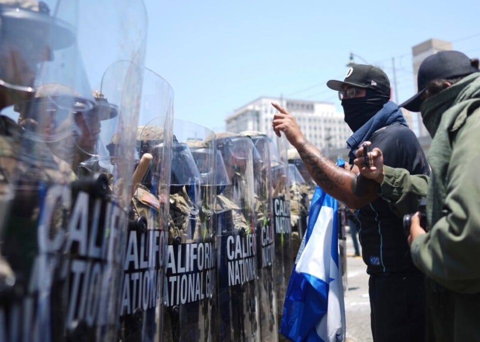 A group of men pointing at riot police

AI-generated content may be incorrect.