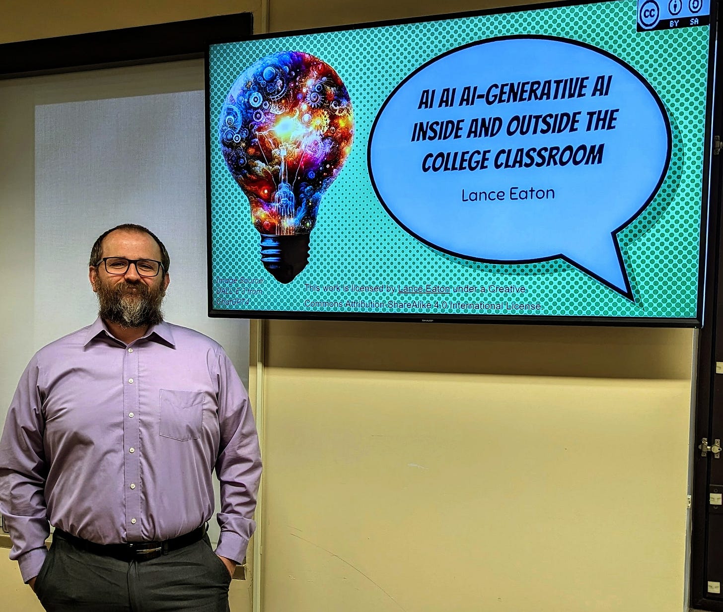Lance Eaton stands to the left of a screen with the title slide of his presentation.