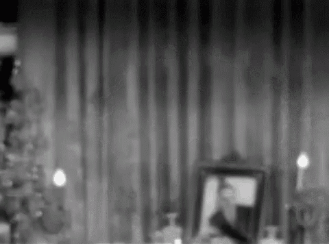 a black and white photo of a christmas tree with a picture of a man in a frame .