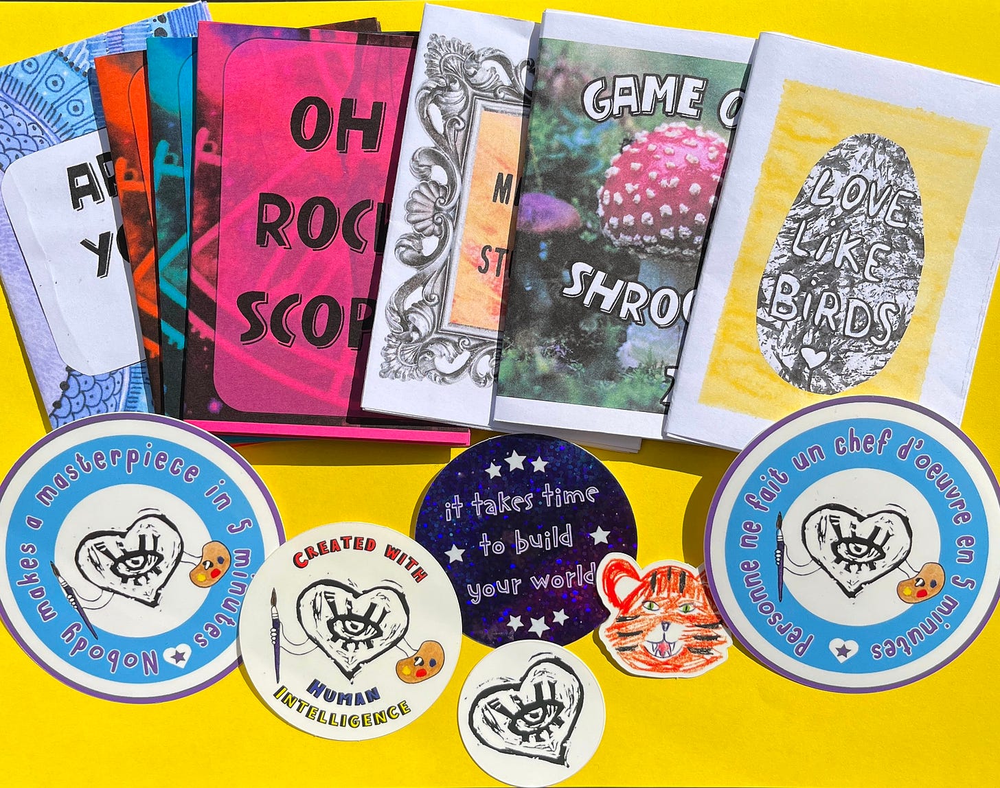 Photo où l'on voit une partie des articles disponibles sur ma boutique (mini zines et autocollants).