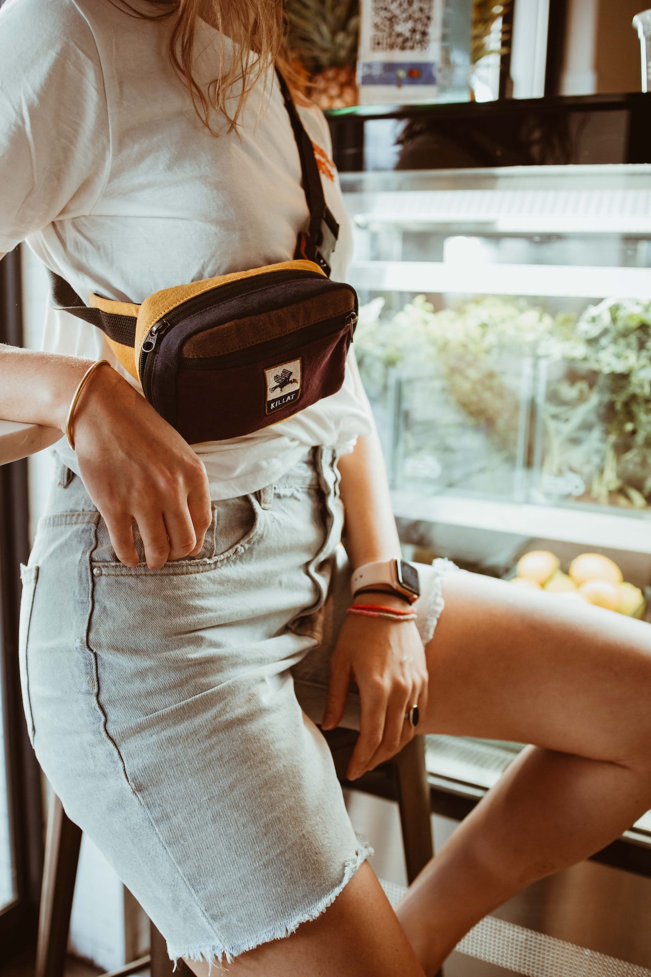 New Moon sling bag on a woman with a white shirt in a sandwich shop