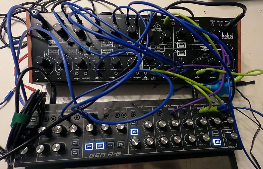 Two synthesizers connected by wires for Joy of Synths.
