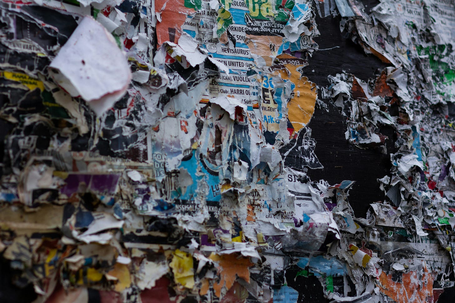 Poster board on a street with layers upon layers of new and old posters.