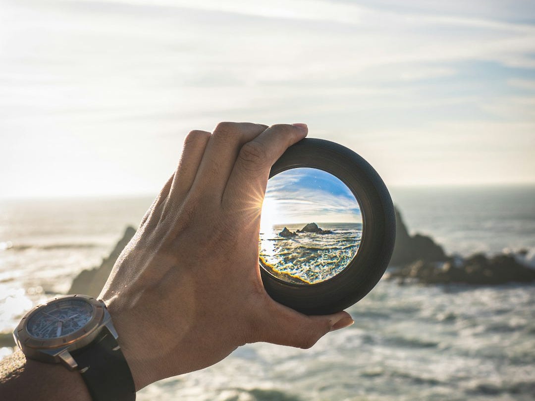 person holding round black frame person holding round black frame