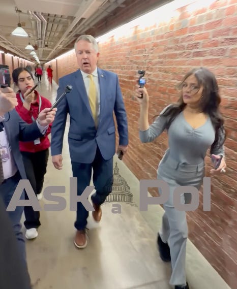 Reporters record a Senator in a suit as they walk through a tunnel walled with red bricks. photo Matt Laslo © www.askapolpolitics.com