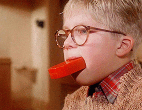 a young boy wearing glasses is eating a red bar