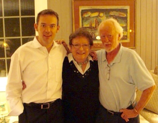 Mother, father, and son standing on living room posing for photo
